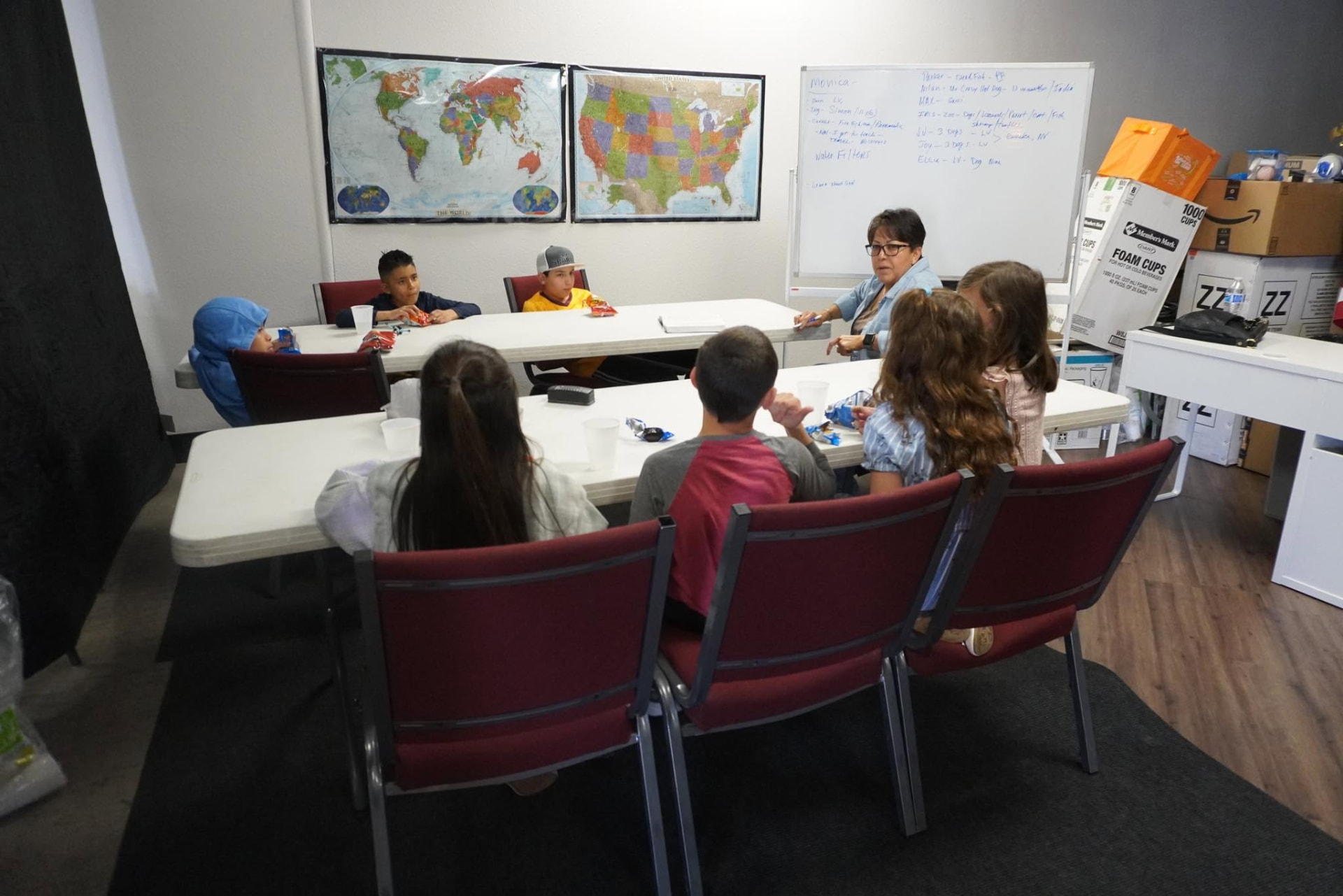 A Dunamis Kids leader reading with a small group of children in a supervised classroom